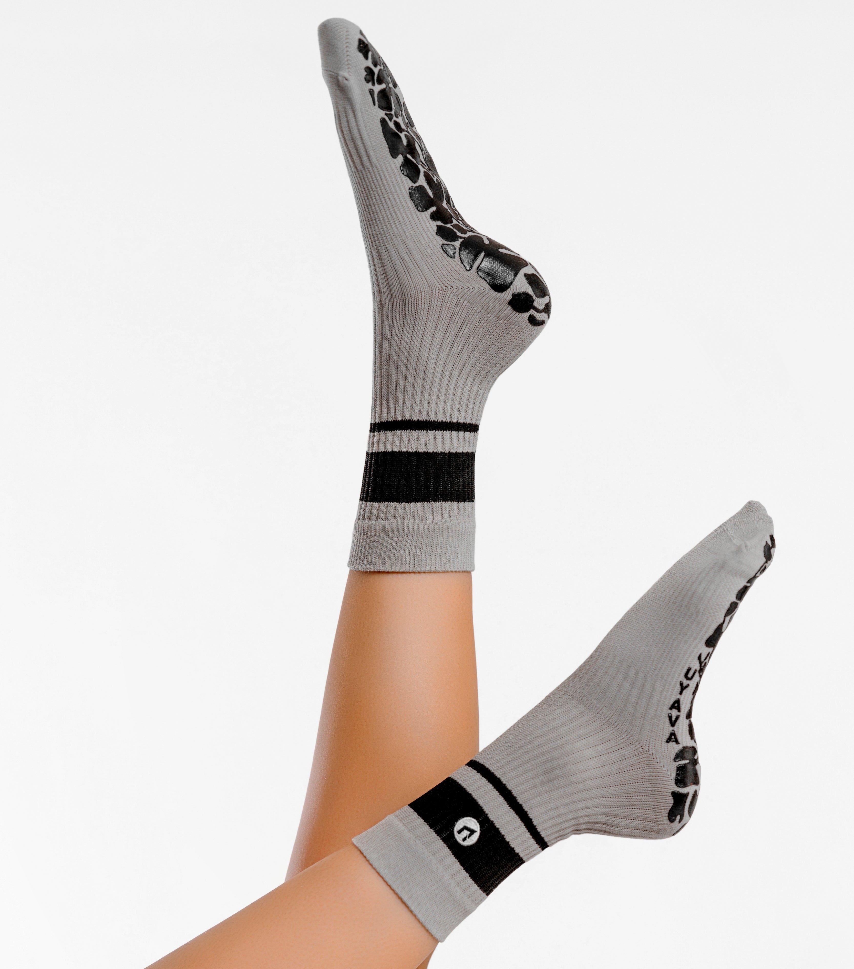 Gray socks with black accents worn by a person on a white background